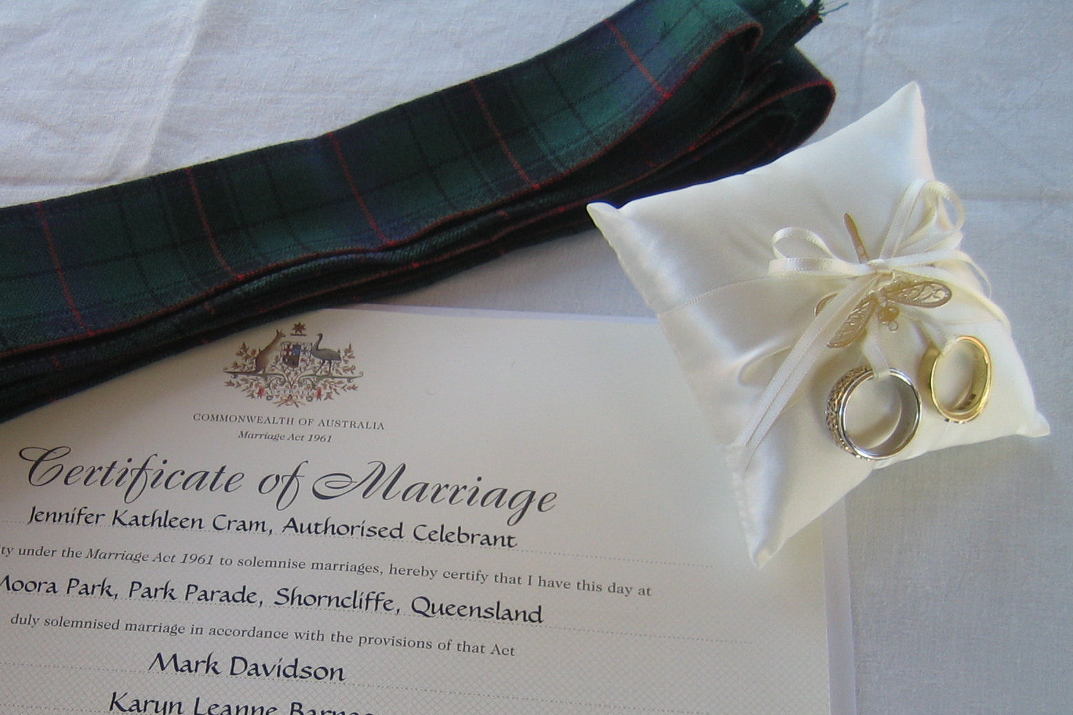 Tartan Handfasting Band with wedding rings on a
                  pillow